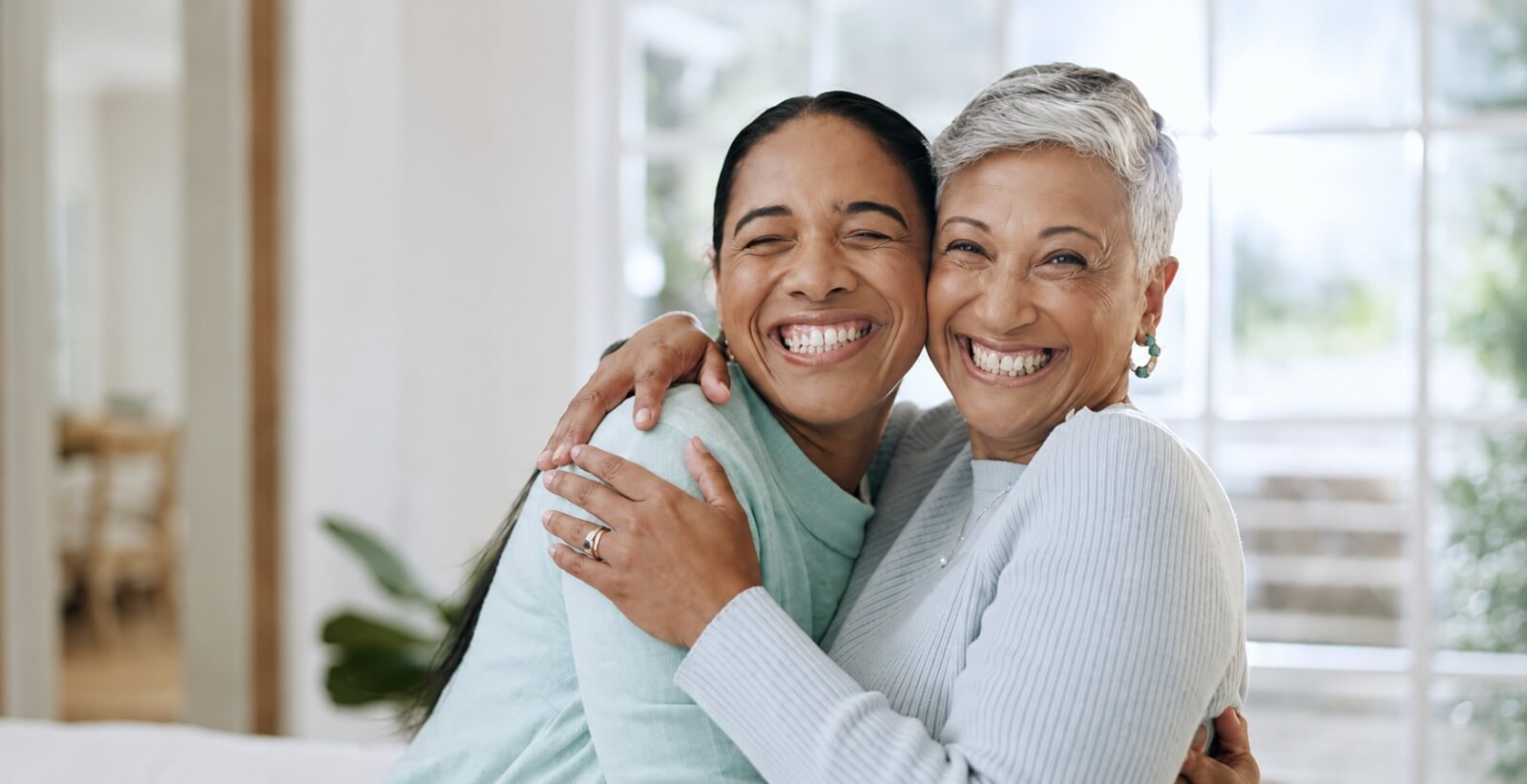 A senior woman and her daughter laughing together